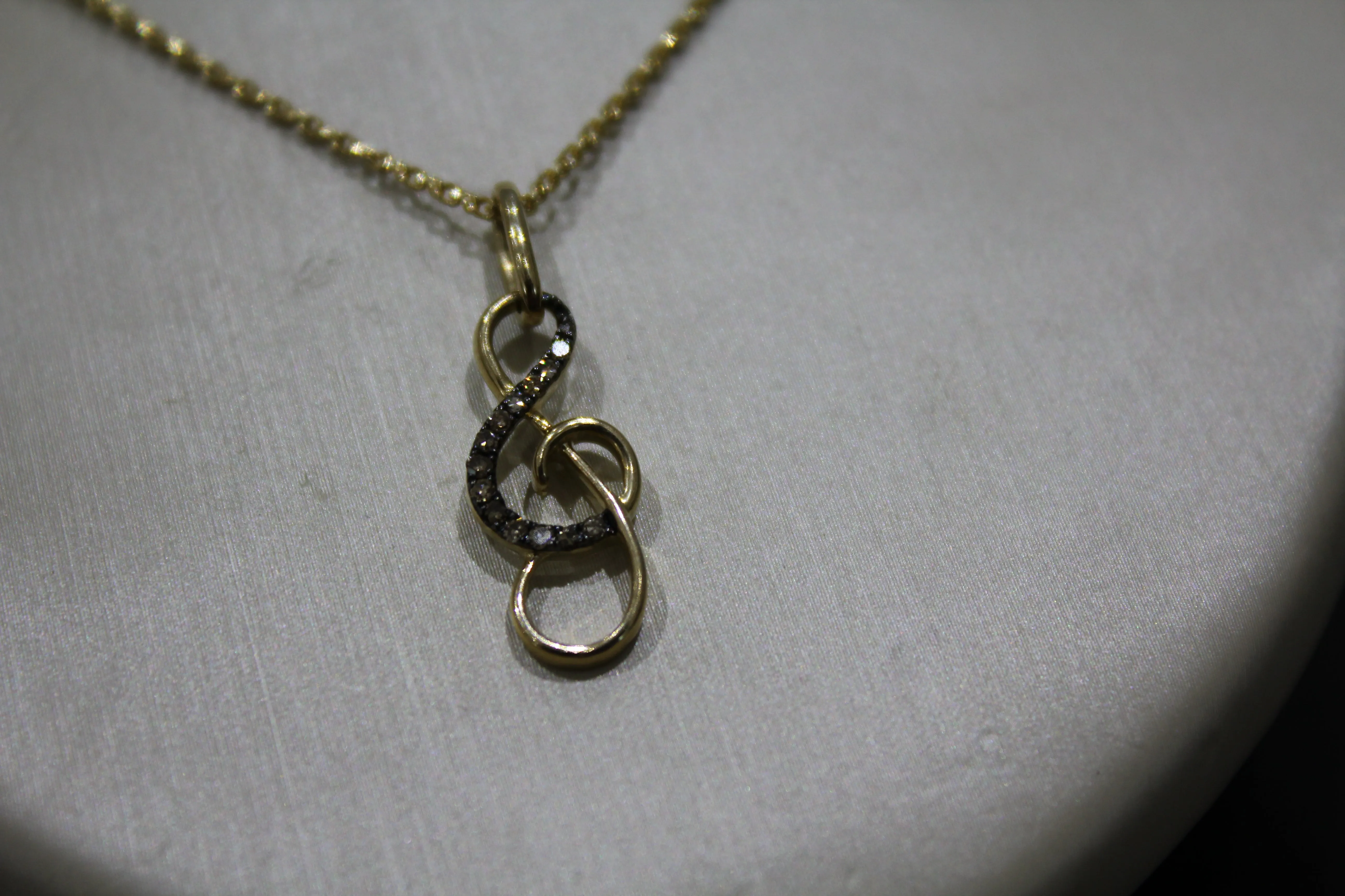 FS1002: 10k 0.10 ct TW diamond treble clef pendant with box chain.